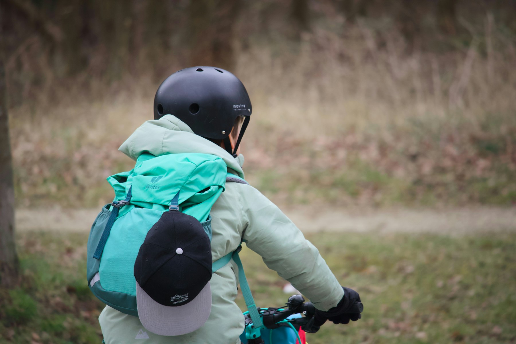 Ciclista con casco in un percorso verde